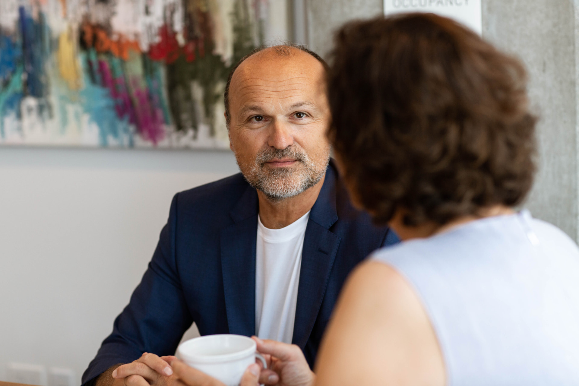 Sascha Menesi in conversation with a client over coffee